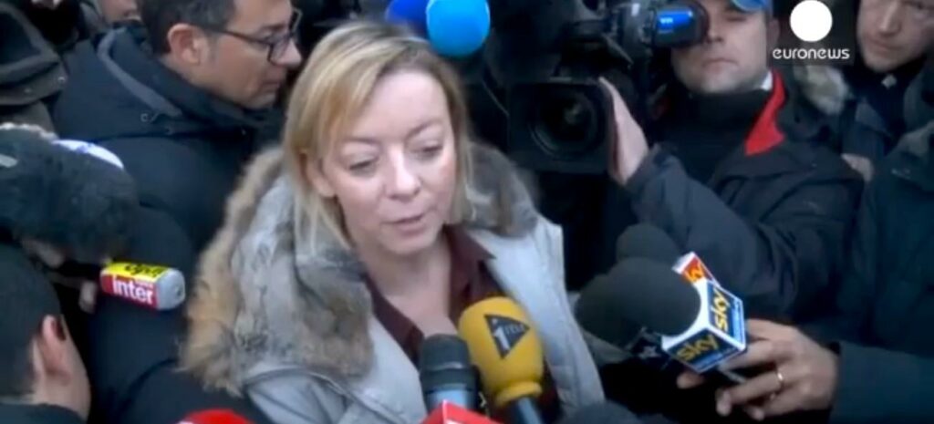 En kvinna omges av journalister. (AI text)