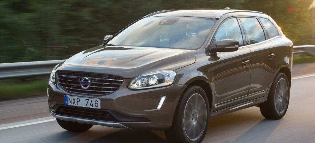 En Volvo XC90 SUV kör längs en landsväg. (AI text)