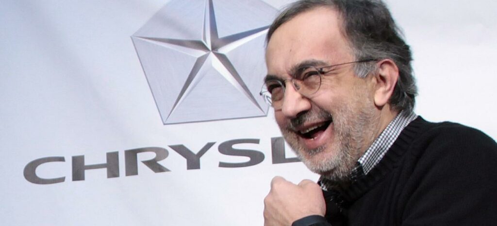 En man leder ett leende mot en Chrysler-logotyp. (AI text)