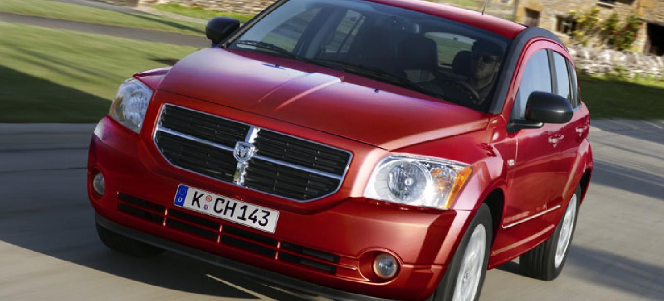 En röd Dodge Caliber kör nerför en landsväg. (AI text)