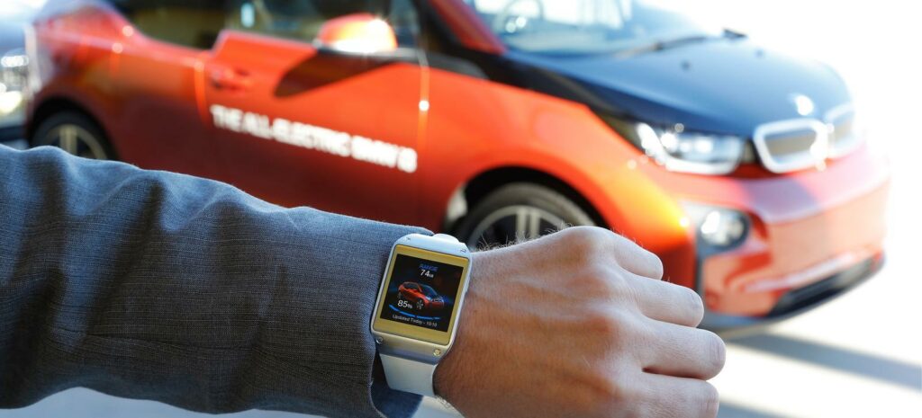 En man bär en smartklocka bredvid en BMW i3. (AI text)