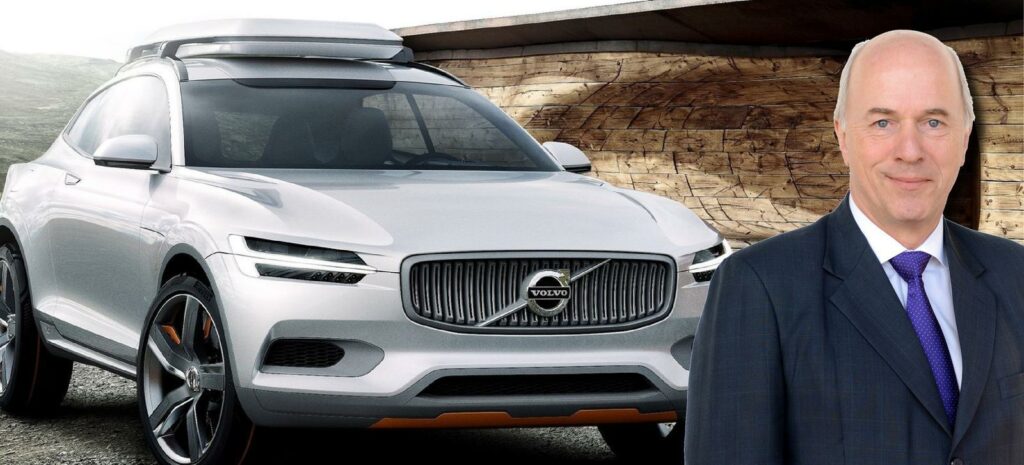 En man i kostym och slips står bredvid en Volvo XC90. (AI text)