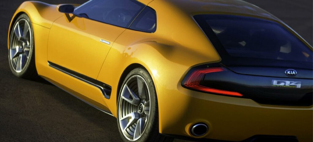 En gul sportbil kör nerför en väg. (AI text)