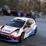 En rallybil kör nedför en backe. (AI text)