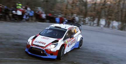 En rallybil kör nedför en backe. (AI text)