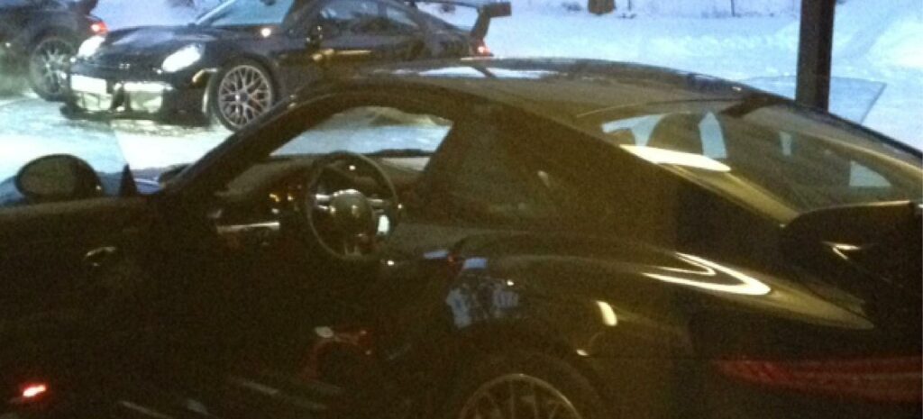 En Porsche 911 GTS parkerad i en snötäckt parkeringsplats. (AI text)