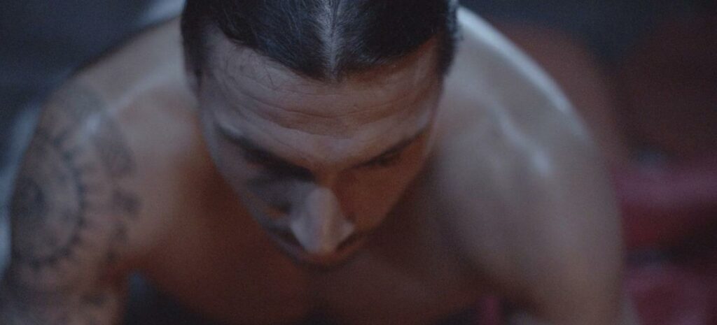 En man med tatuager och en bil. (AI text)