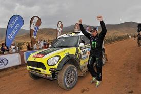 En man står bredvid en Mini Countryman. (AI text)