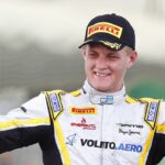 En racerförare vinkar till publiken efter att ha vunnit loppet. (AI text)