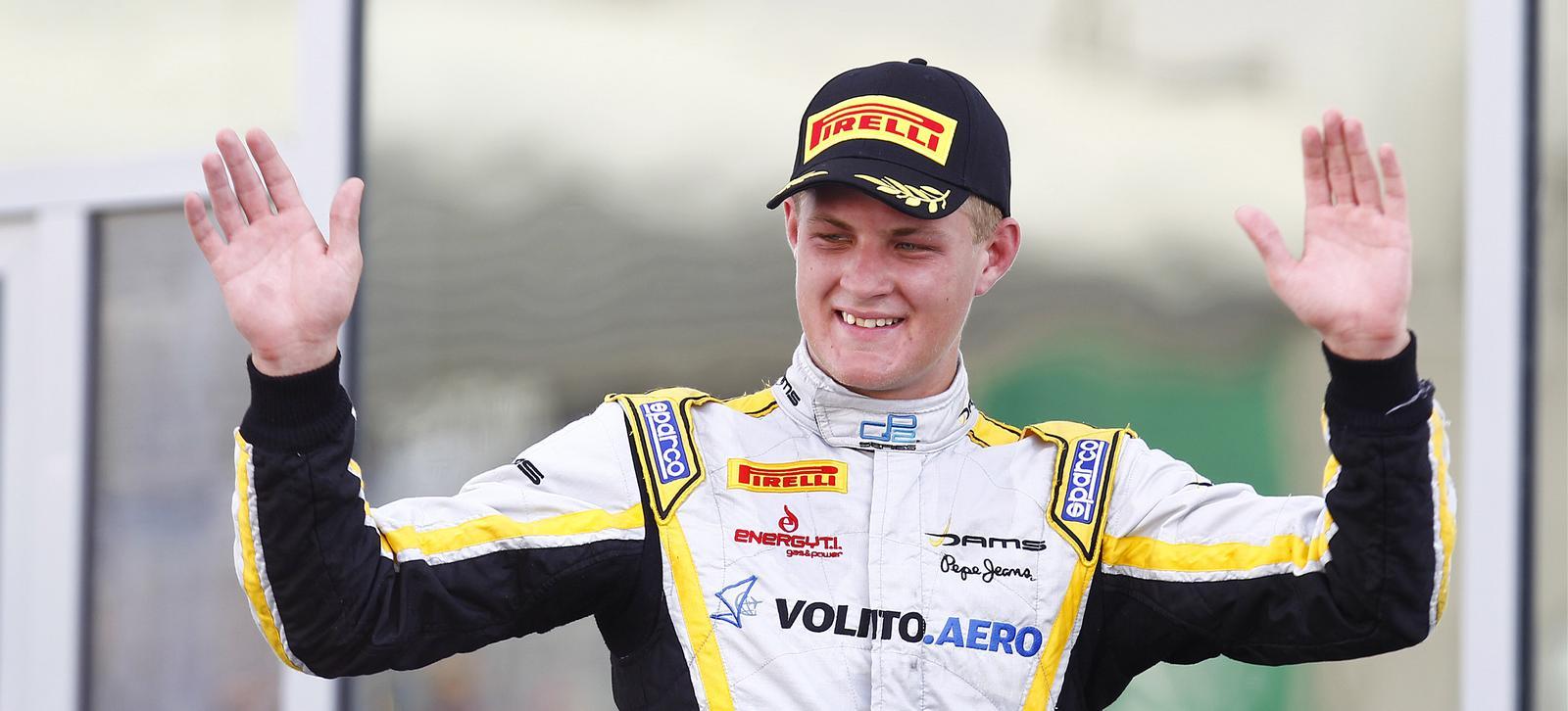 En racerförare vinkar till publiken efter att ha vunnit loppet. (AI text)