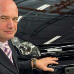 En man i kostym står bredvid en Volkswagen Golf. (AI text)