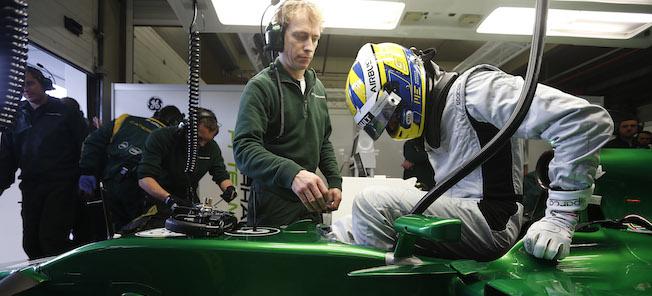 En racingbil i en garage där en mekaniker arbetar på den. (AI text)