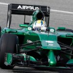 En grön formelbil kör på en bana. (AI text)