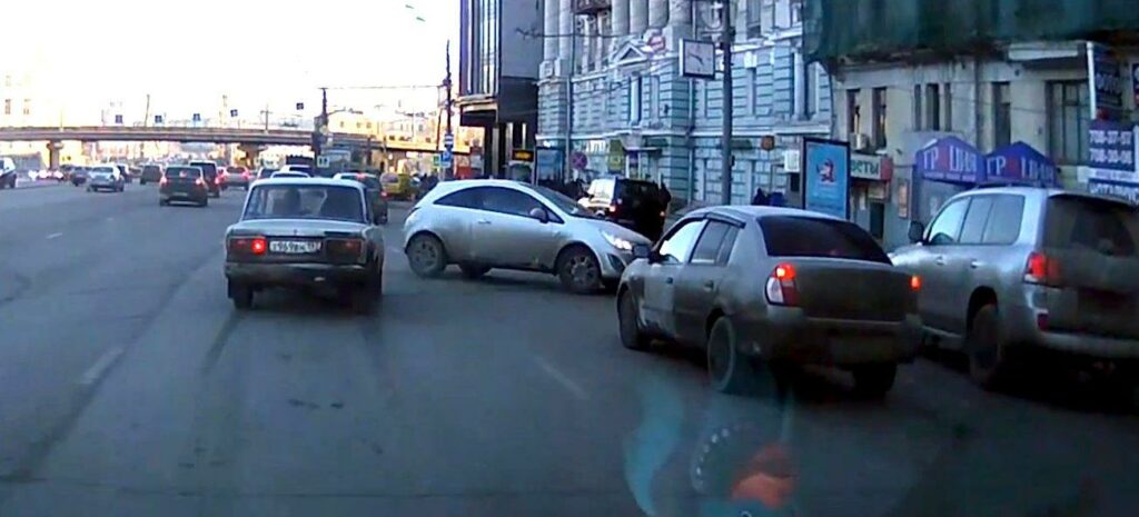 En bil kör nerför en stadsgata. (AI text)