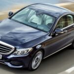 En Mercedes-Benz E-saloon kör på en väg. (AI text)