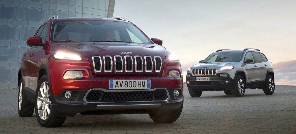 En Jeep Cherokee parkerad framför ett byggnad. (AI text)