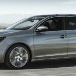Peugeot 208 kör längs vägen. (AI text)