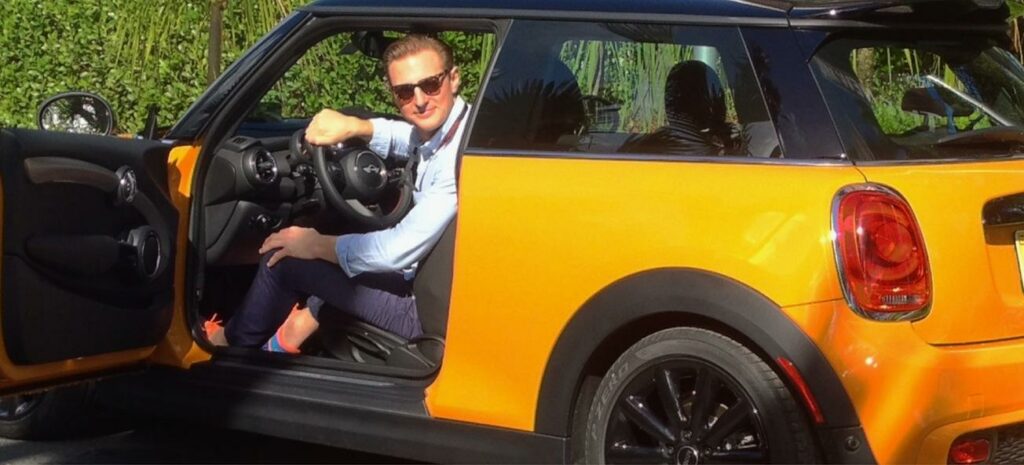 En man sitter i en Mini Cooper. (AI text)
