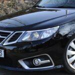 En svart Saab C3 sedan parkerad på en gata. (AI text)