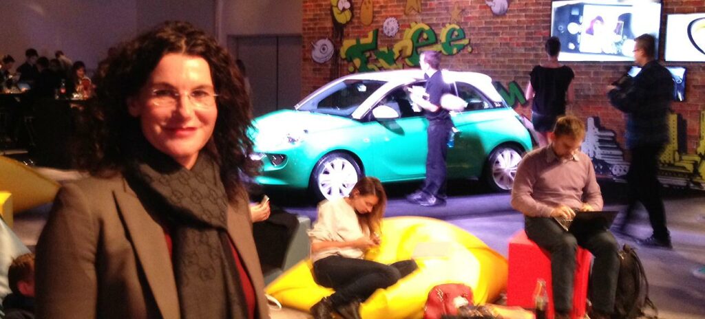 En kvinna står framför en bil. (AI text)