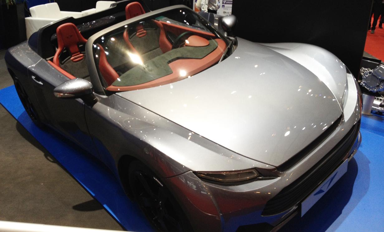 En silverfärgad sportbil visas upp på en bilmesse. (AI text)