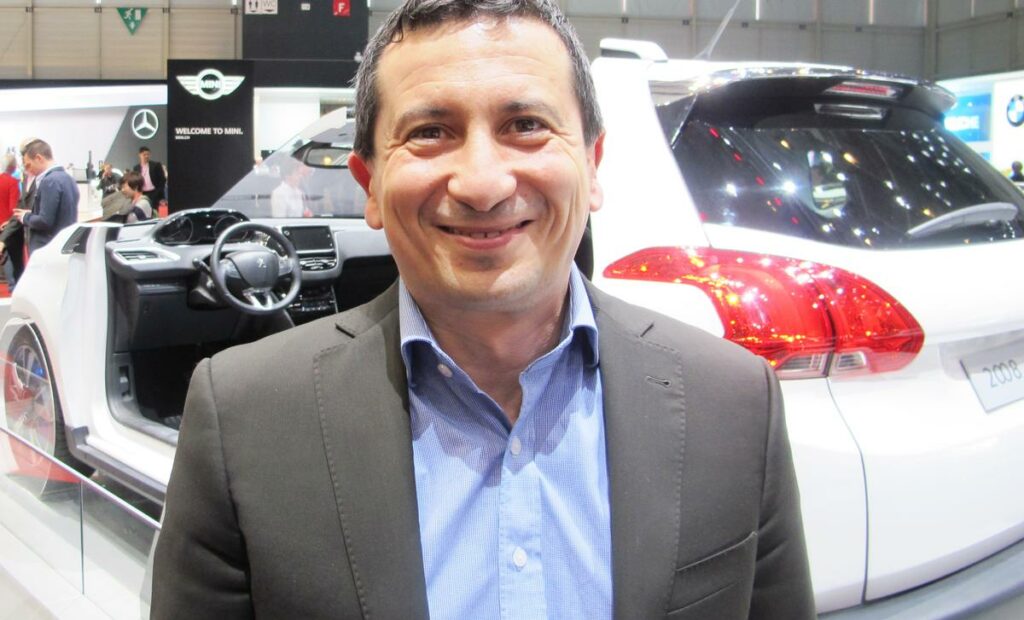 En man står framför en bil. (AI text)