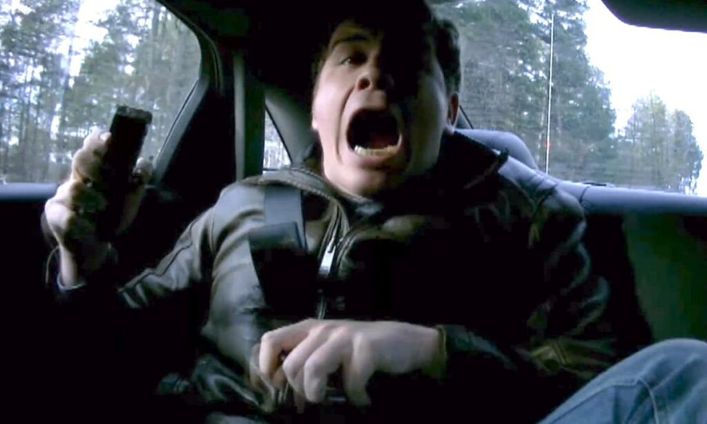 En man kör en bil med munnen öppen. (AI text)