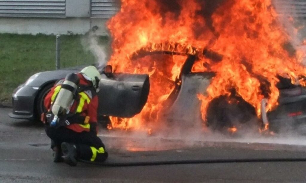 En brandman släcker en bilbrand. (AI text)