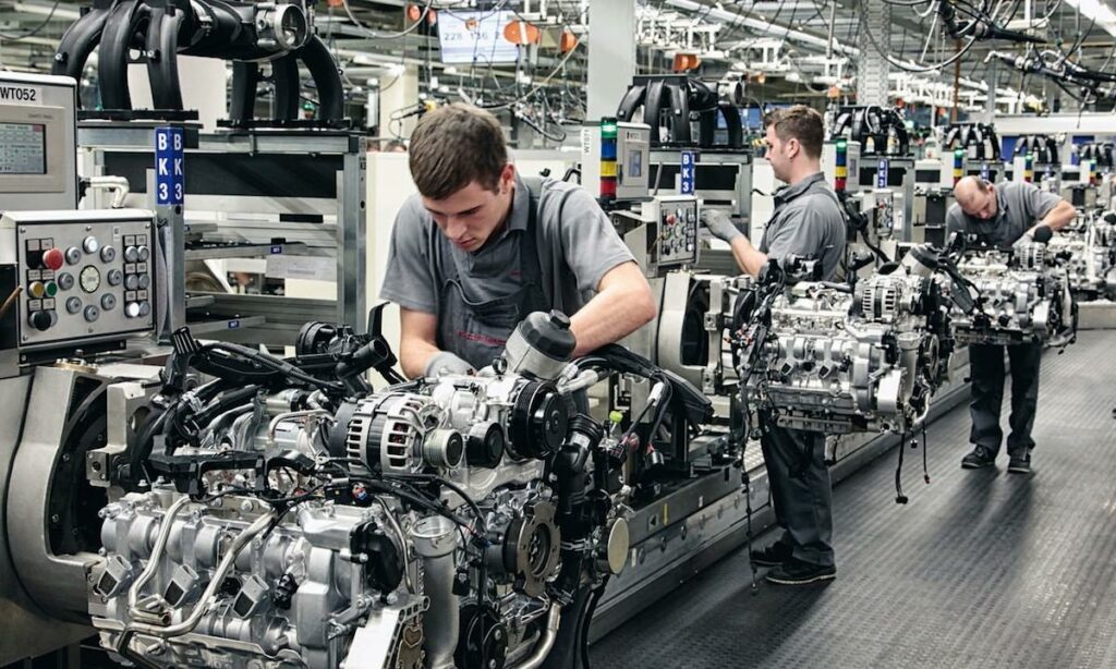 En biltillverkare monterar en motor i en fabrik. (AI text)