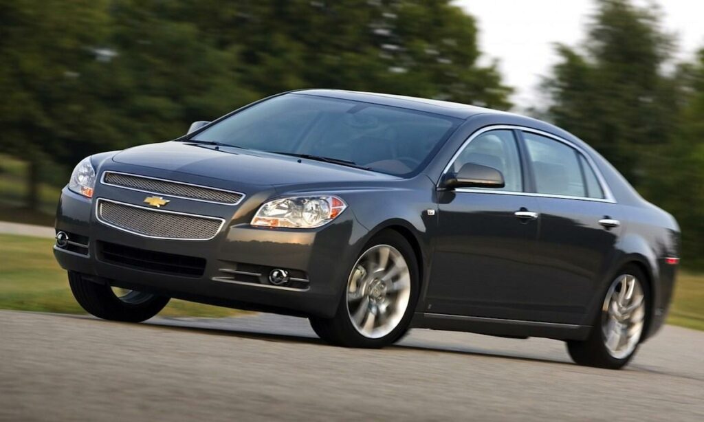 Chevrolet Malibu kör längs vägen. (AI text)
