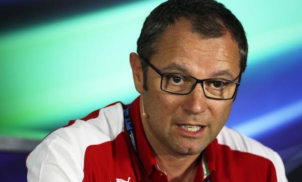 En man i glasögon och en röd skjorta sitter vid ett podiet. (AI text)