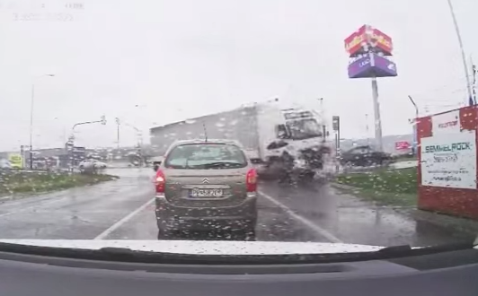 En bil kör nerför en väg i regnet. (AI text)