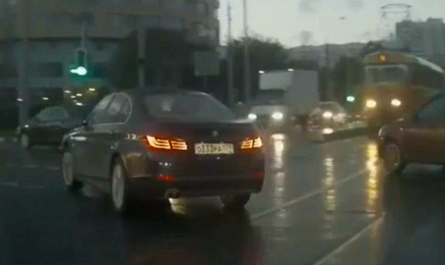 En bil kör genom en gata i regn. (AI text)