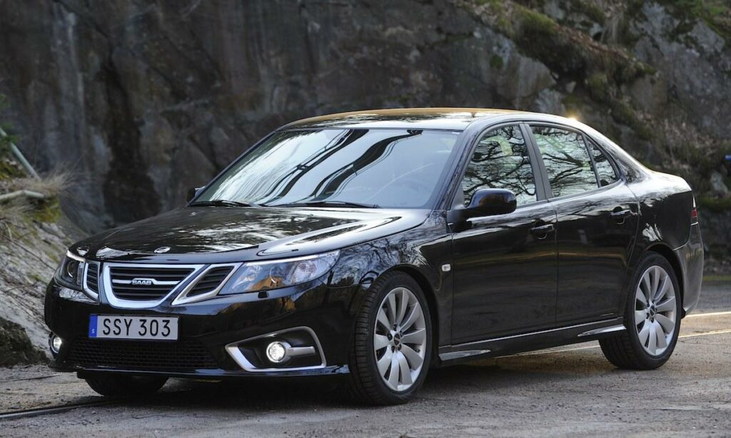 En svart bil parkerad på en stenig väg. (AI text)