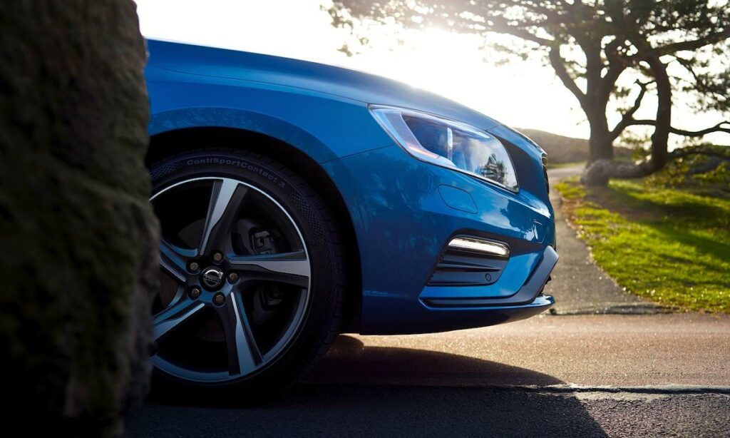 En blå Volvo V60 står parkerad vid en gata. (AI text)