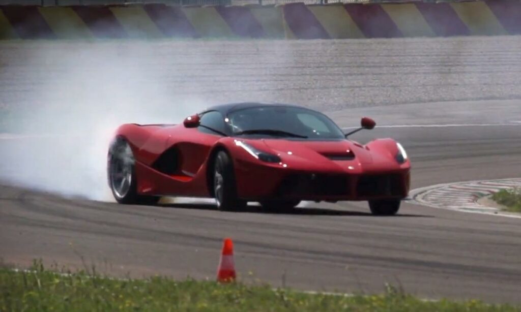 En röd sportbil kör längs banan. (AI text)