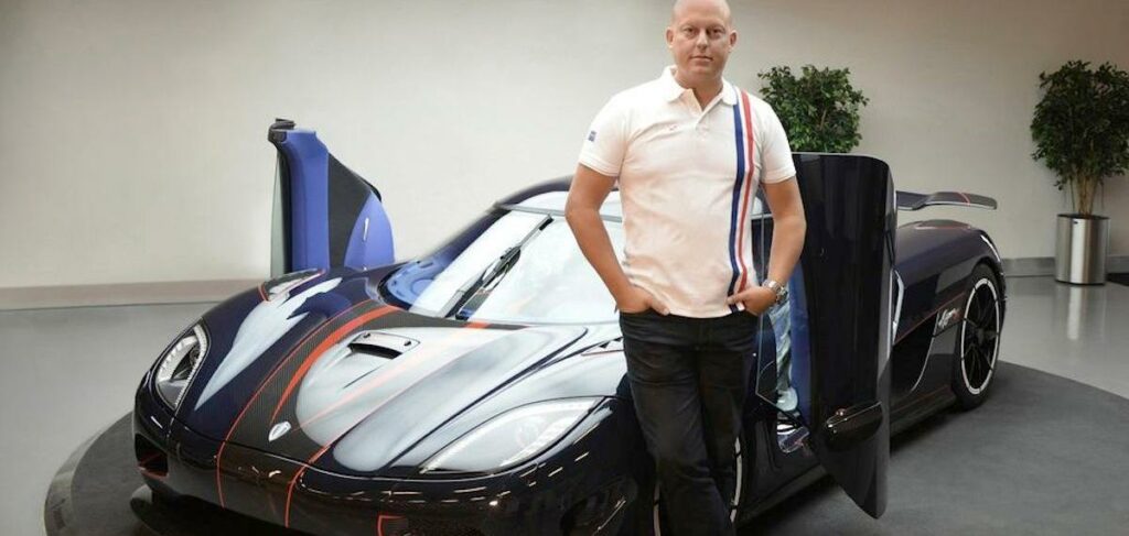 En man står bredvid en sportbil. (AI text)