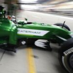 En grön formelbil kör i garaget. (AI text)
