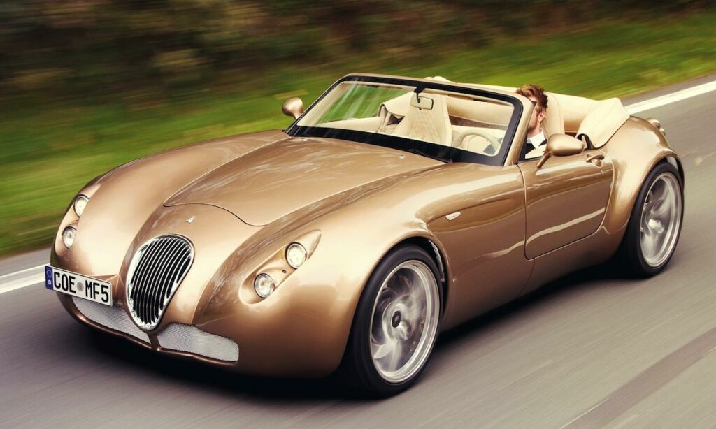 En klassisk sportbil kör längs en landsväg. (AI text)