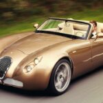 En klassisk sportbil kör längs en landsväg. (AI text)