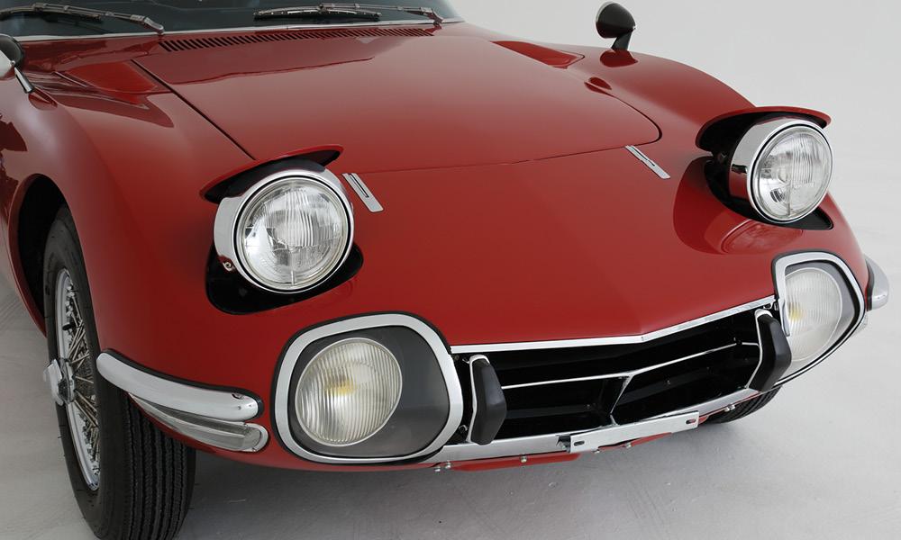 En röd sportbil mot en vit bakgrund. (AI text)