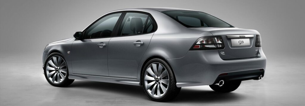 En silverfärgad bil i en grå studio. (AI text)