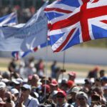 En skara människor som vajar med brittiska flaggor på racbanan. (AI text)