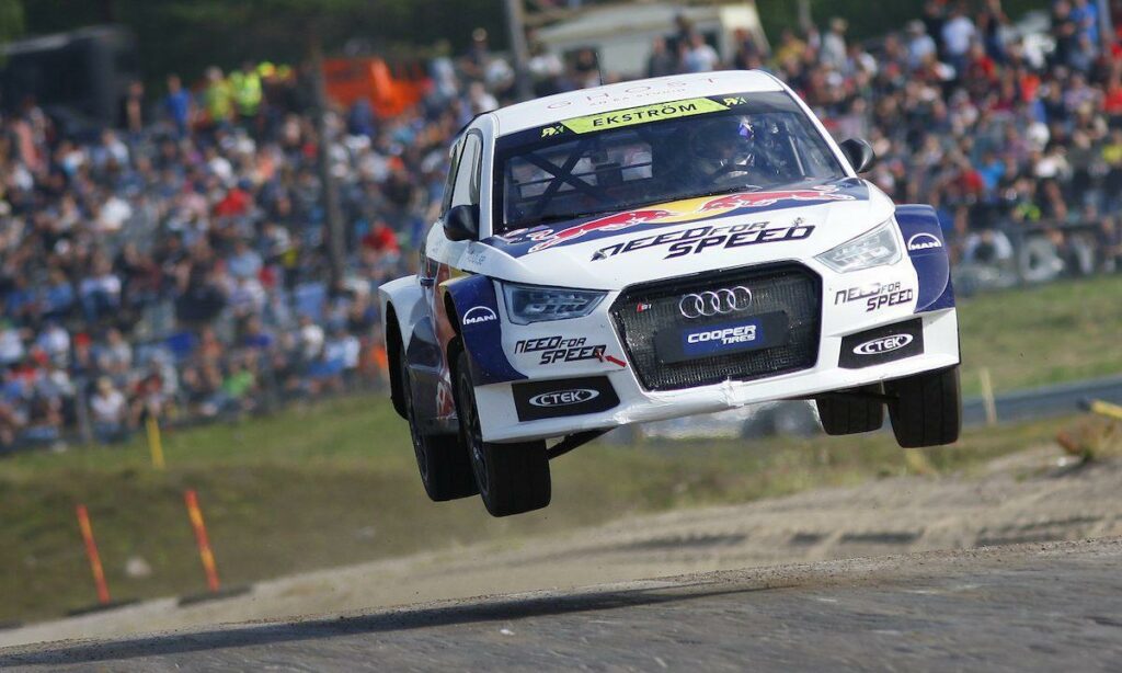En Audi A3 rallybil lyfter i luften. (AI text)