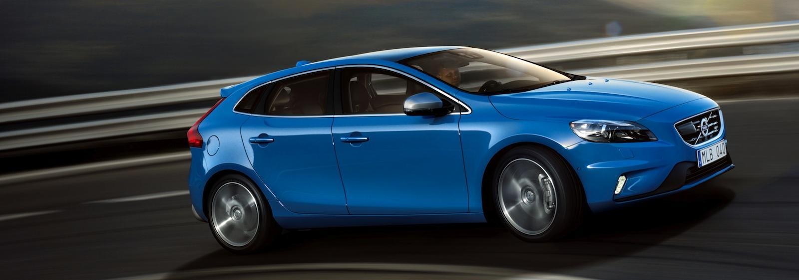 En blå Volvo V40 kör på en väg. (AI text)