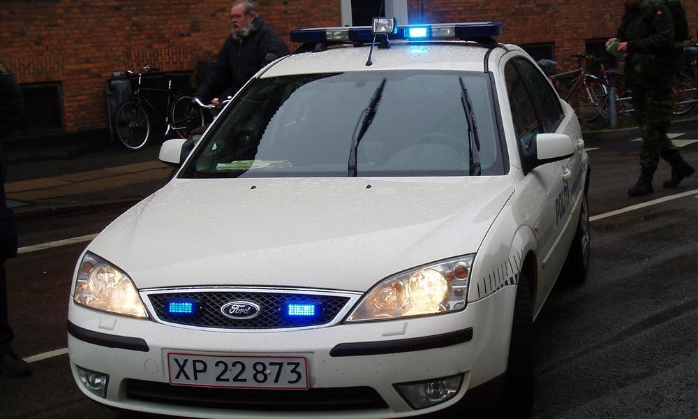 En polisbil står parkerad på en parkeringsplats. (AI text)