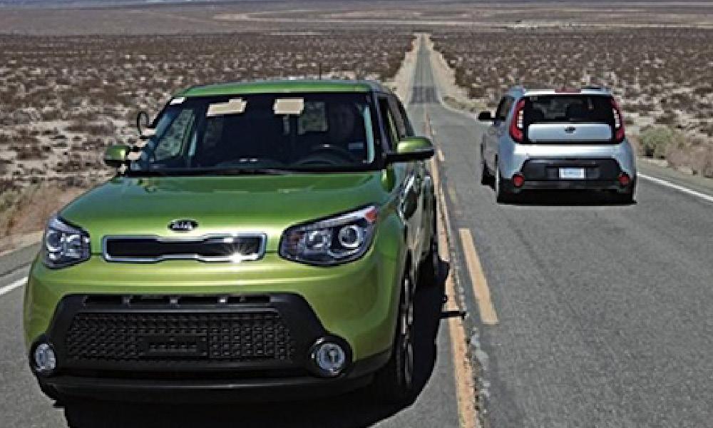 En grön Kia Soul kör nedför en ökenväg. (AI text)