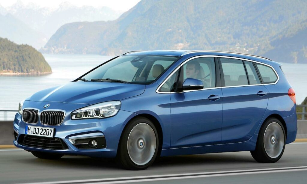 BMW 2-serien touring kör på en bergsväg. (AI text)