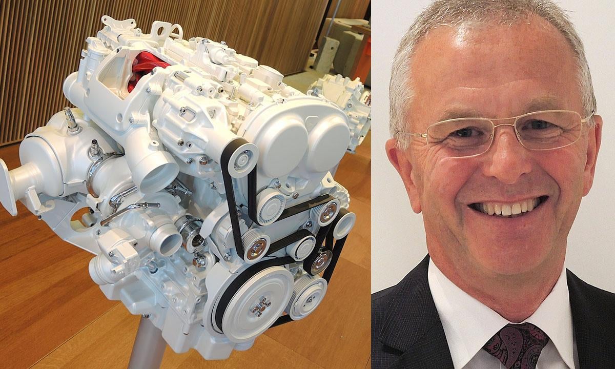 En man i kostym och slips står bredvid en bilmotor. (AI text)