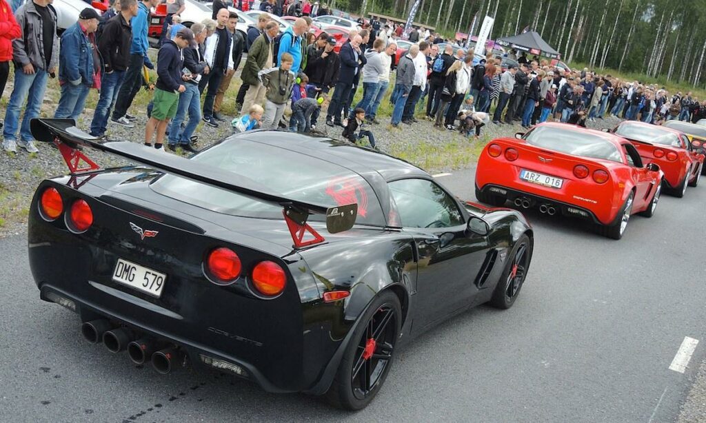 en grupp personer tittar på en bilutställning (AI text)